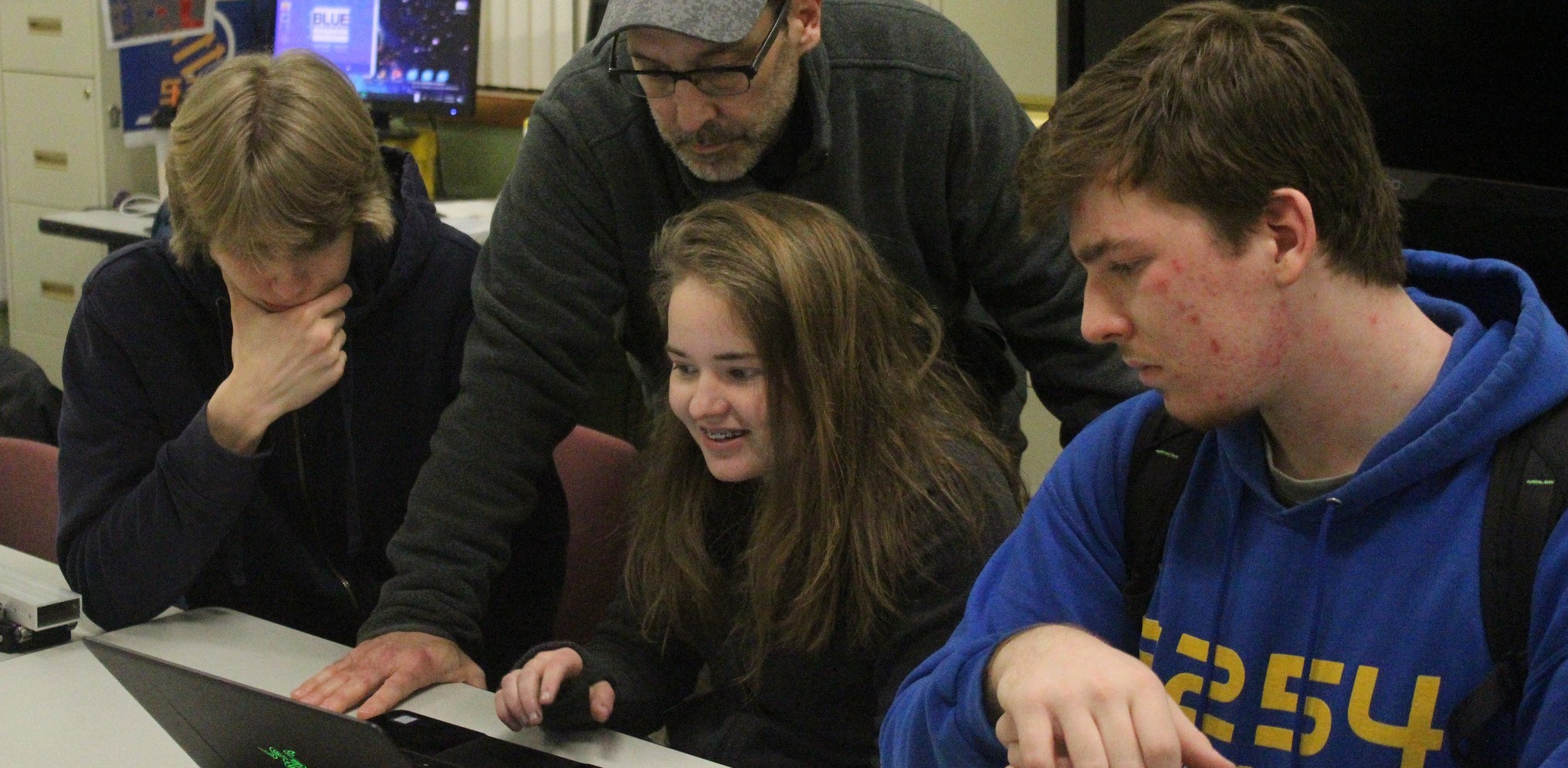 Team members around laptop